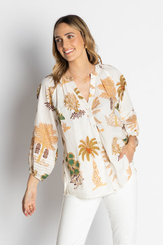 Woman wearing a white blouse with tropical pattern on a plain background Lula Life - Amrita Shirt - White